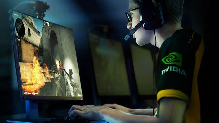 Image of someone in an NVIDIA t-shirt playing an FPS game on their PC and monitor.