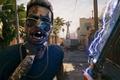 Dead Island 2 player holding zombie and sword