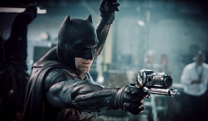 The Batman aims his gun.