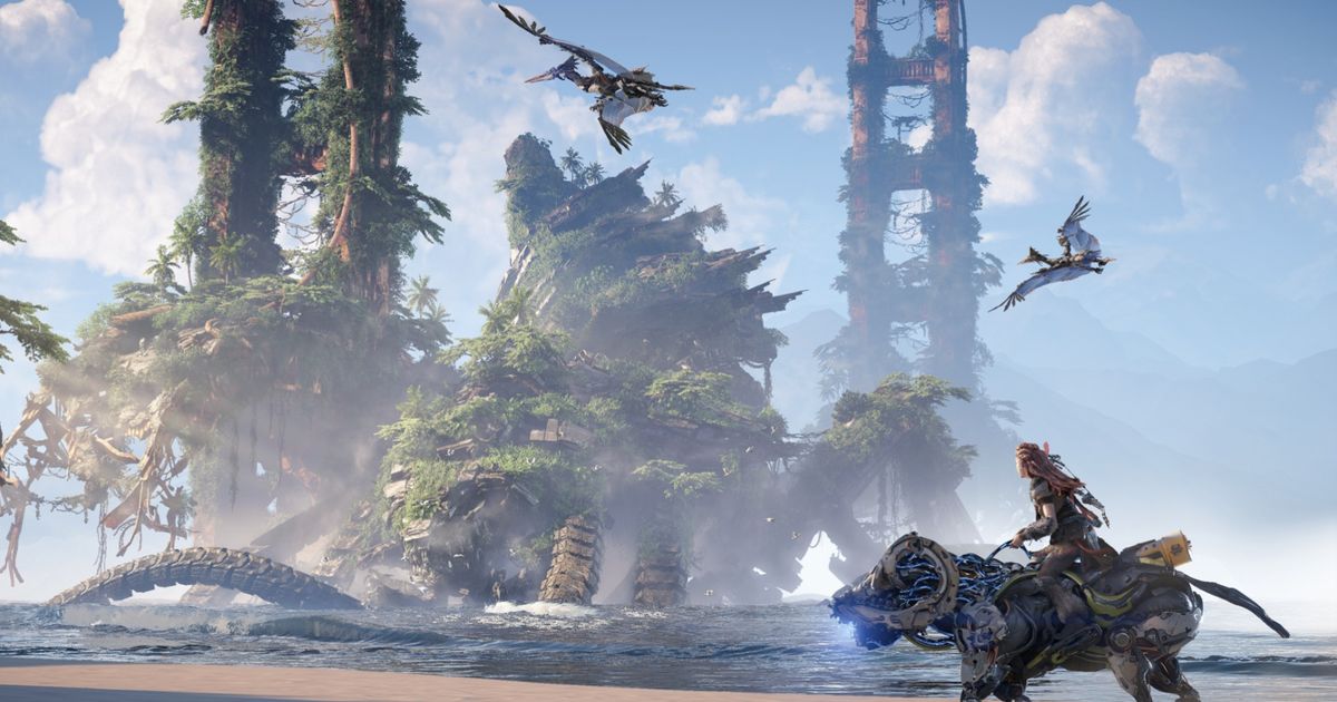 Horizon Forbidden West. Aloy riding a charger across the beach with a set of ancient buildings in the background