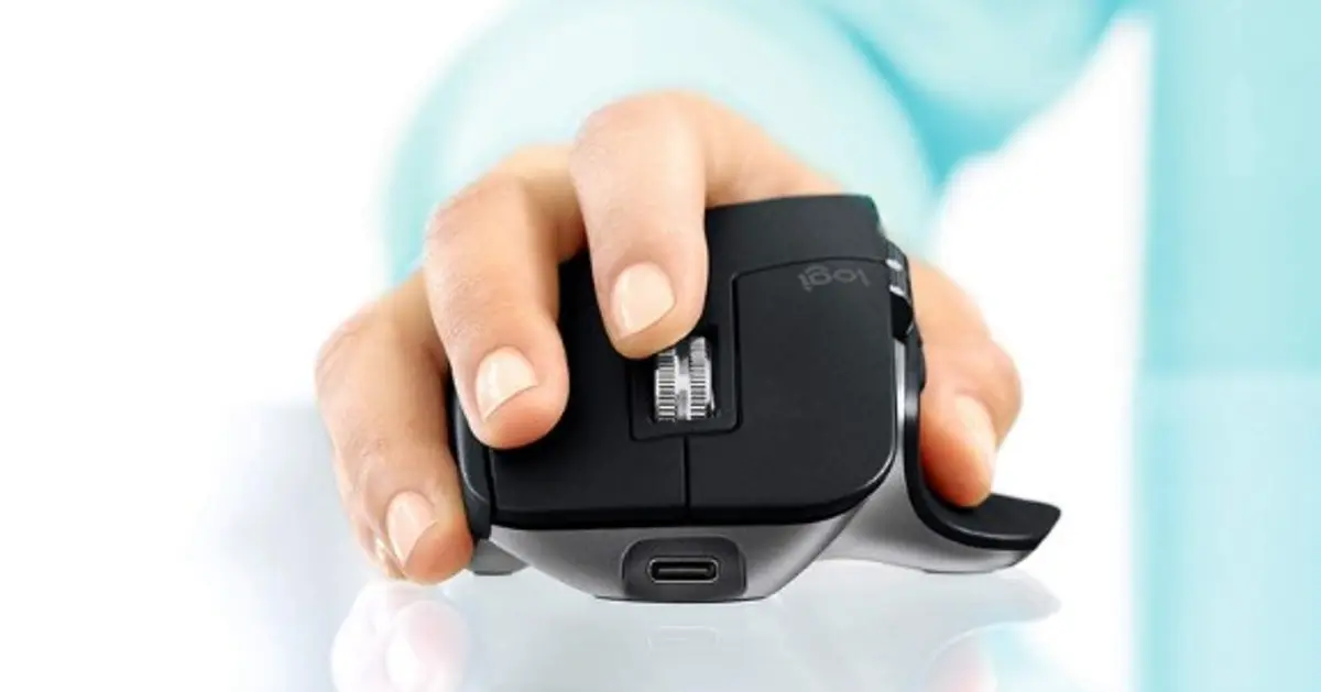 Someone with their hand on a black and grey ergonomic mouse.
