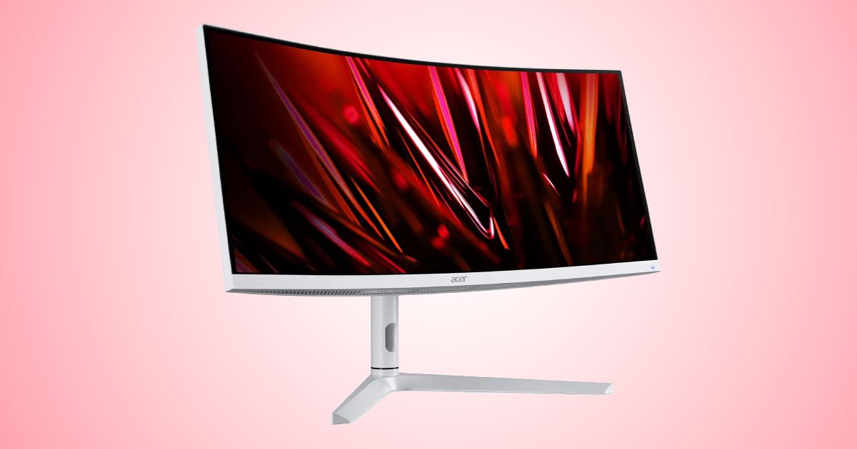 A silver curved gaming monitor with a dark red pattern on the display in front of a gradient red and white background.