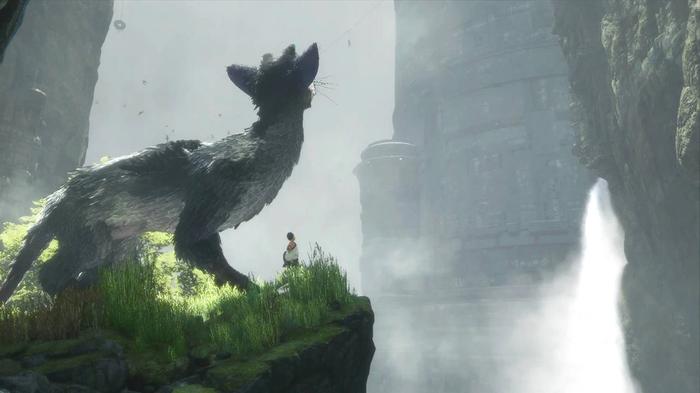 Trico sat with a boy, looking into the distance in The Last Guardian.