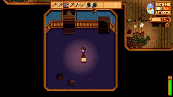 Stardew Valley. The player is standing in the craft room in the community center before it has been repaired. The room has a purple floor and there is a glowing scroll in the middle of it.