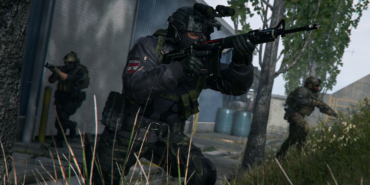 Screenshot of Warzone 2 players holding guns near a tree at the bottom of a hill