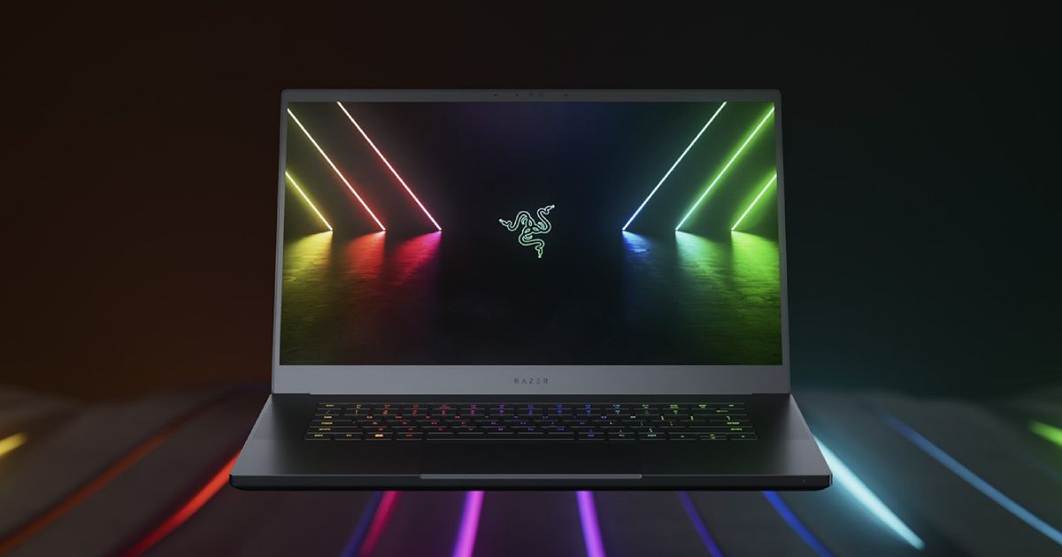 A thin black laptop with multicoloured backlit keys to match the lights it's sat on and on the screen.