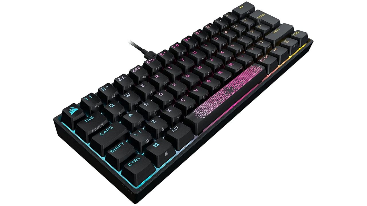 Corsair K65 Mini product image of a black wired keyboard with blue, pink, and orange lighting behind the keys.