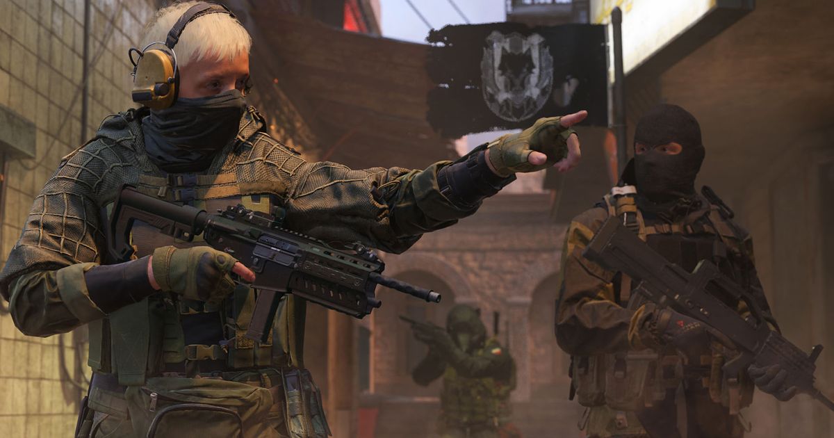 Modern Warfare 3 player pointing while carrying SMG with teammate carrying gun in background