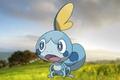 The Pokemon Sobble stood against a grassy hill background.