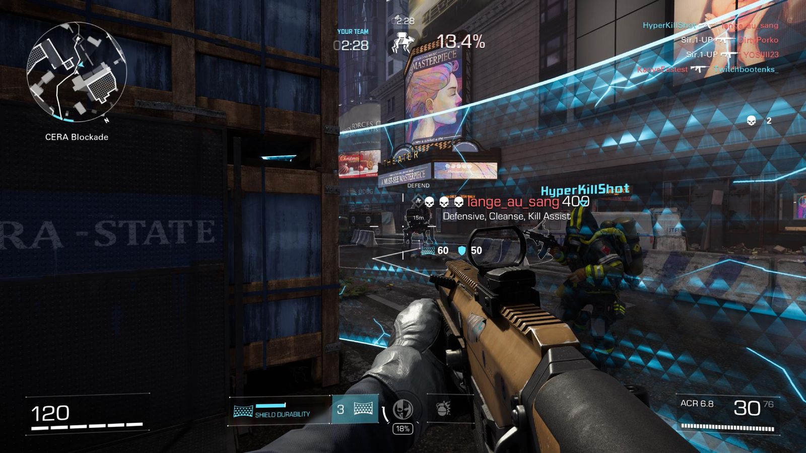 A first-person screenshot of XDefiant gameplay, showing the player holding an assault rifle and looking down a road in a city with a large blue barrier for protection.