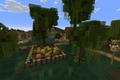 A Minecraft world with green marshland, willow trees, and wooden structures.