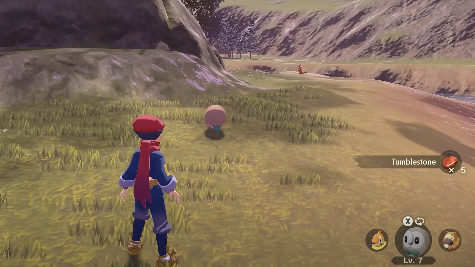 A Pokémon Trainer uses their Rowlet to farm Tumblestone from a rock in Obsidian Fieldlands of Pokémon Legends: Arceus.