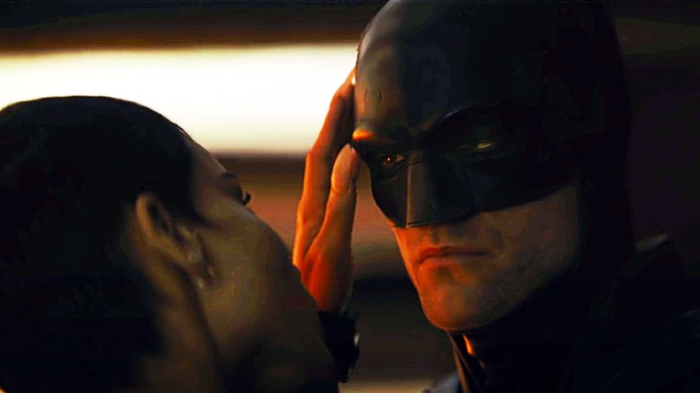 Catwoman touches Batman on his face.