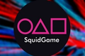 Image of Squid Game Token Logo on Red and Blue Streaked Blurred Background