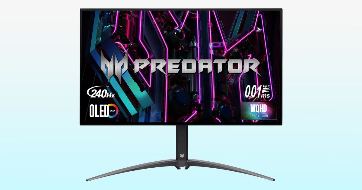 A dark grey near-frameless monitor with grey Predator branding on the display in front of pink and blue lights.
