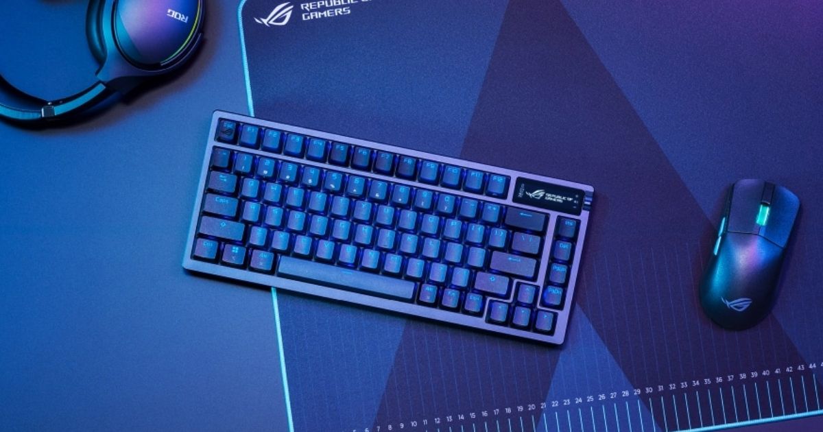 A black 75% keyboard in a dark blue-lit room next to a mouse and gaming headset.