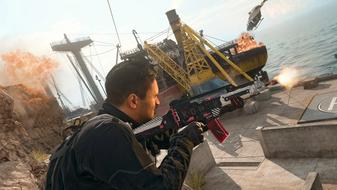 Warzone player aiming down sights of gun with exploding ship in background