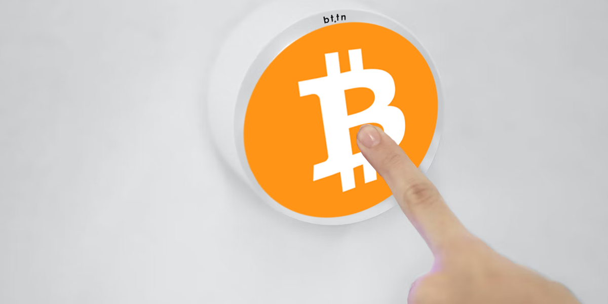Finger pressing a Bitcoin button