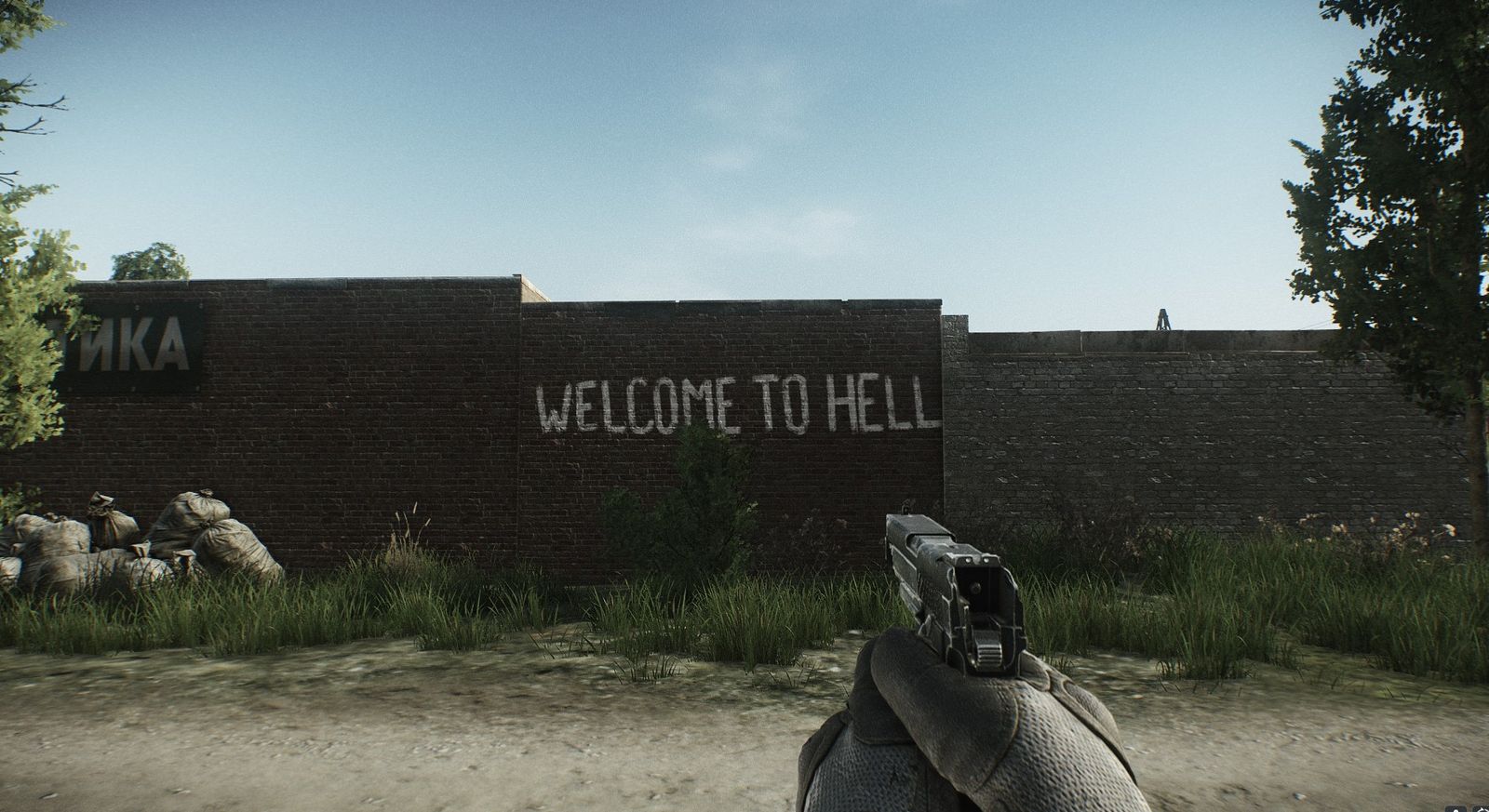 A PMC player looking at the 'Welcome to Hell' graffiti on the Customs map in Escape From Tarkov.