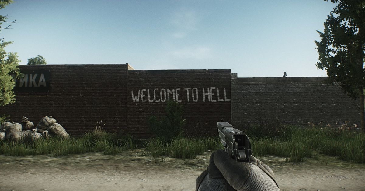 A PMC player looking at the 'Welcome to Hell' graffiti on the Customs map in Escape From Tarkov.