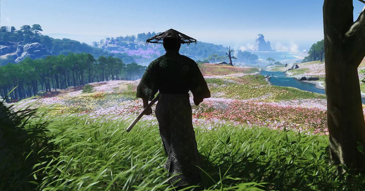 A samurai in black ropes looking out over hills covered in trees and mulitcolored flowers.