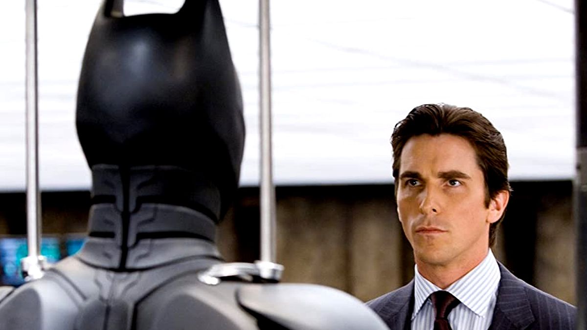 Christian Bale looks at his Batman suit.