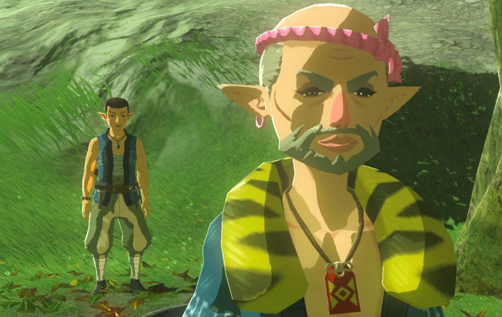 Close-up of Bolson wearing a pink rope tied around his head, a blue and yellow animal-print jacket, and a red necklace.