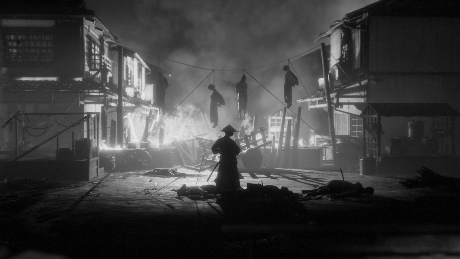 A samurai standing in a burning town with bodies hanging from a rope in the background.