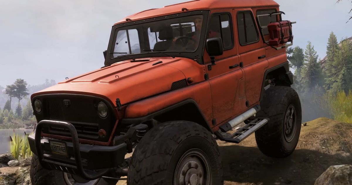 An orange 4x4 Jeep posing on top of a cliff 