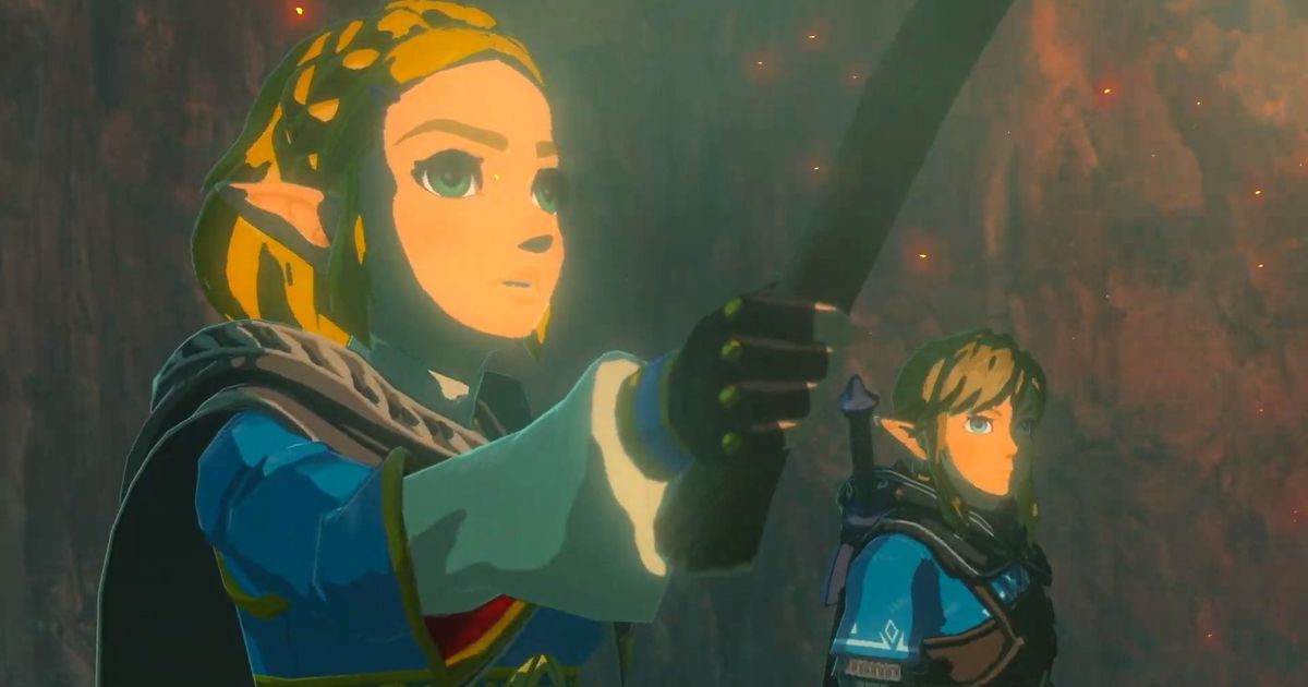 A screenshot of Princess Zelda and Link from the Breath of the Wild. Zelda is in the foreground with her hand out holding something, while Link is in the background. They are both dressed in blue, stood in a red, misty cave setting.