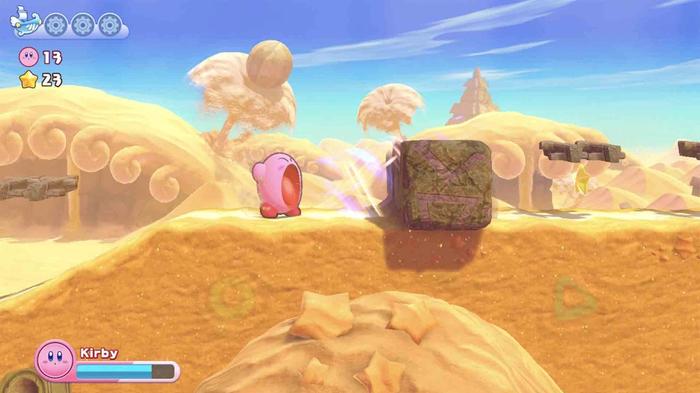 Kirby sucking up a rock in a desert in Kirby's Return to Dream Land Deluxe.