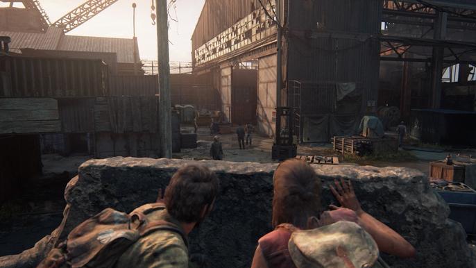 Image of Joel and Tess hiding behind cover in The Last of Us Part I.