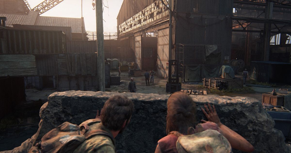 Image of Joel and Tess hiding behind cover in The Last of Us Part I.