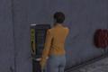 GTA Online The Contract DLC Player at payphone accepting payphone hit mission. Player is wearing grey jeans and a yellow leather jacket with their back to the screen. They have short cropped brown hair.