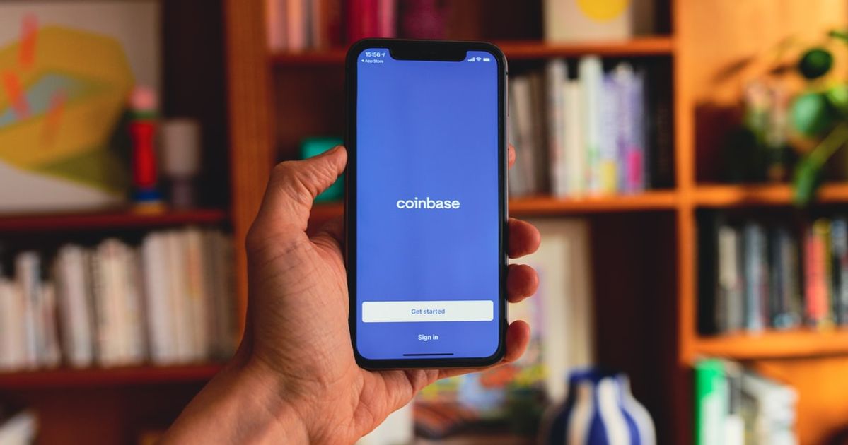 Hand holding a phone with the Coinbase application open.