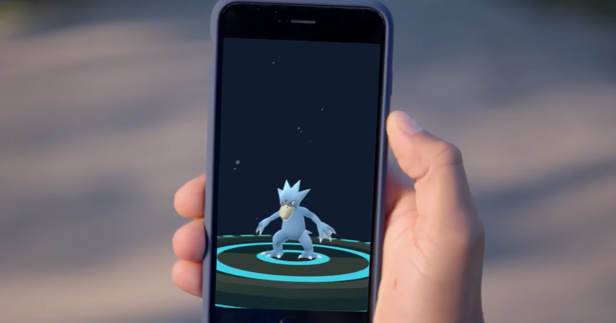Player holding a phone showing their Golduck in Pokemon GO.