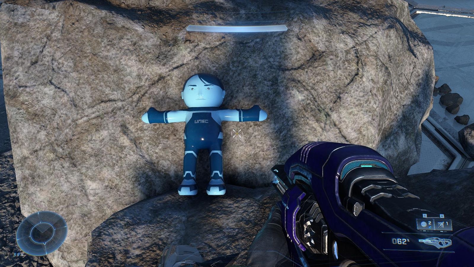 A blue plush doll is placed on a rock. 