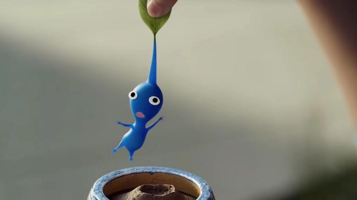 A blue Pikmin is pulled out of the dirt b his leaf in Pikmin Bloom.