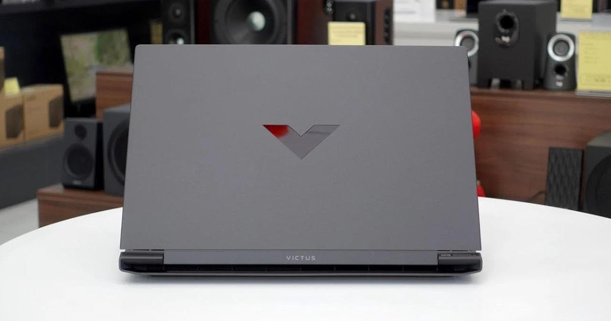 A dark grey laptop with a glossy black V logo on the back.