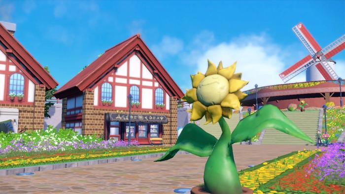 A sunny path leading to a windmill in Pokemon Scarlet and Violet.