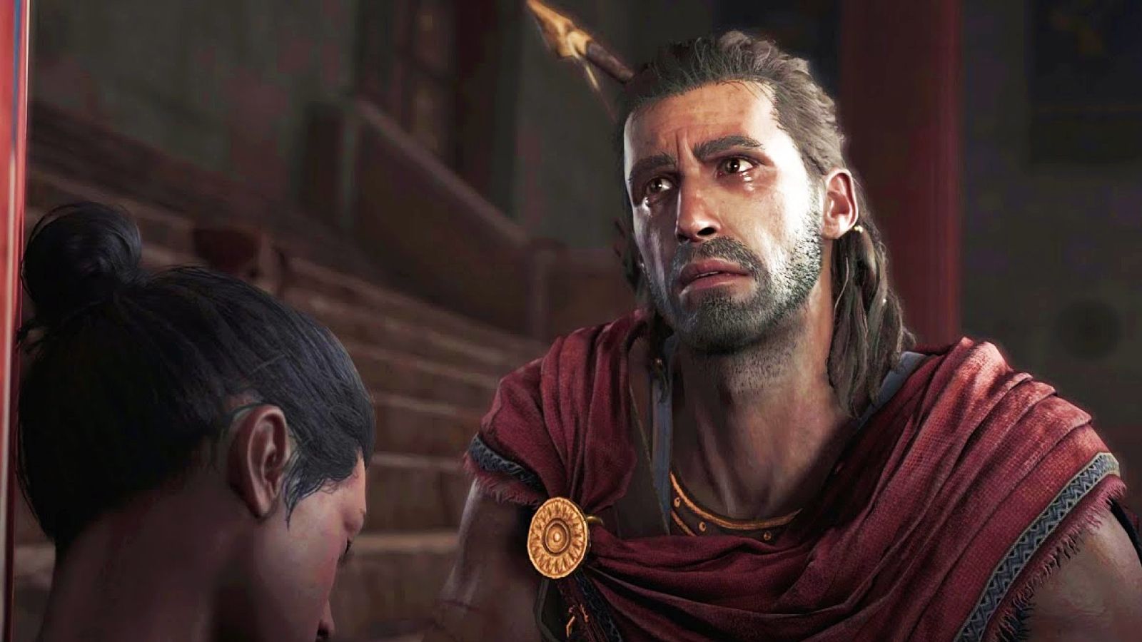 Assassin's Creed Odyssey - man with long brown hair and red cape cries over a woman with her head bowed.