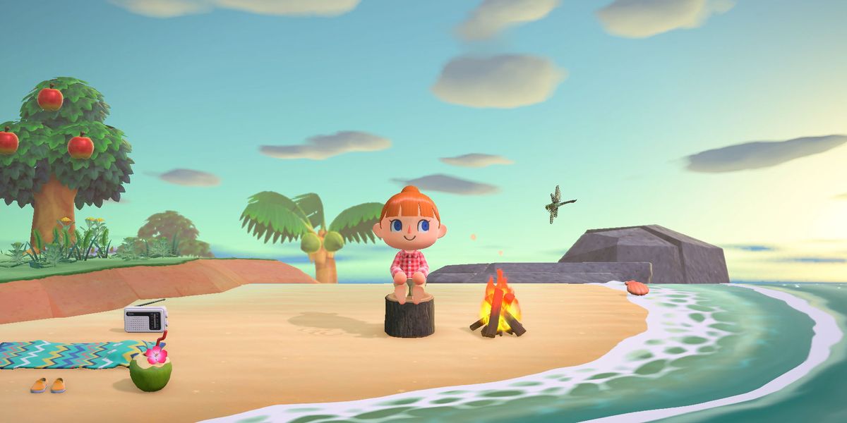 A player sits on a wooden stool on the beach of their island in Animal Crossing: New Horizons.