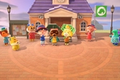A group of Villagers, Tom Nook and Isabelle stand outside of the Town Hall in Animal Crossing: New Horizons. The caption reads 'All Starter Villagers'.