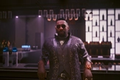 Solomon Reed (Idris Elba) stood at the Black Sapphire bar, in Cyberpunk 2077: Phantom Liberty
