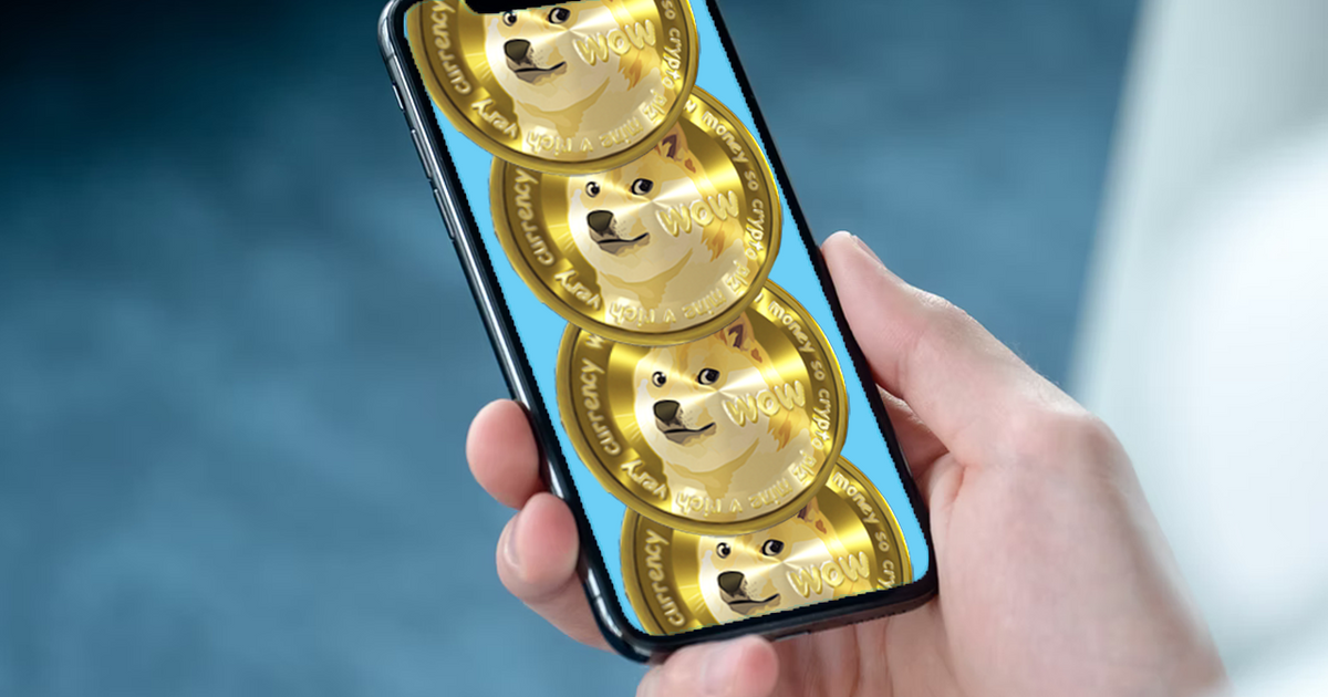 Image of four Dogecoin coins on a phone in a hand.