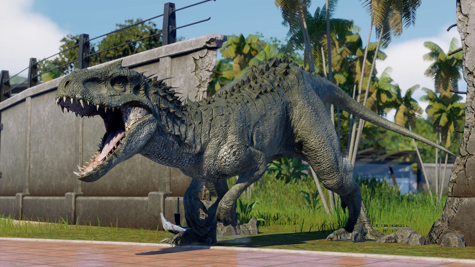 In-game shot from Jurassic World Evolution 2 of a dinosaur breaking out of a grey stone fence.