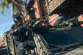 Warzone 2 player hanging on vehicle door holding rifle