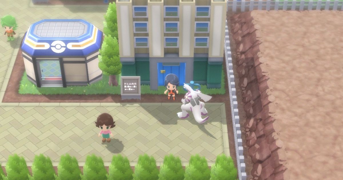 A Pokémon Trainer and their Palkia standing outside of the Eterna Condominiums of Eterna City in Pokémon Brilliant Diamond and Shining Pearl.