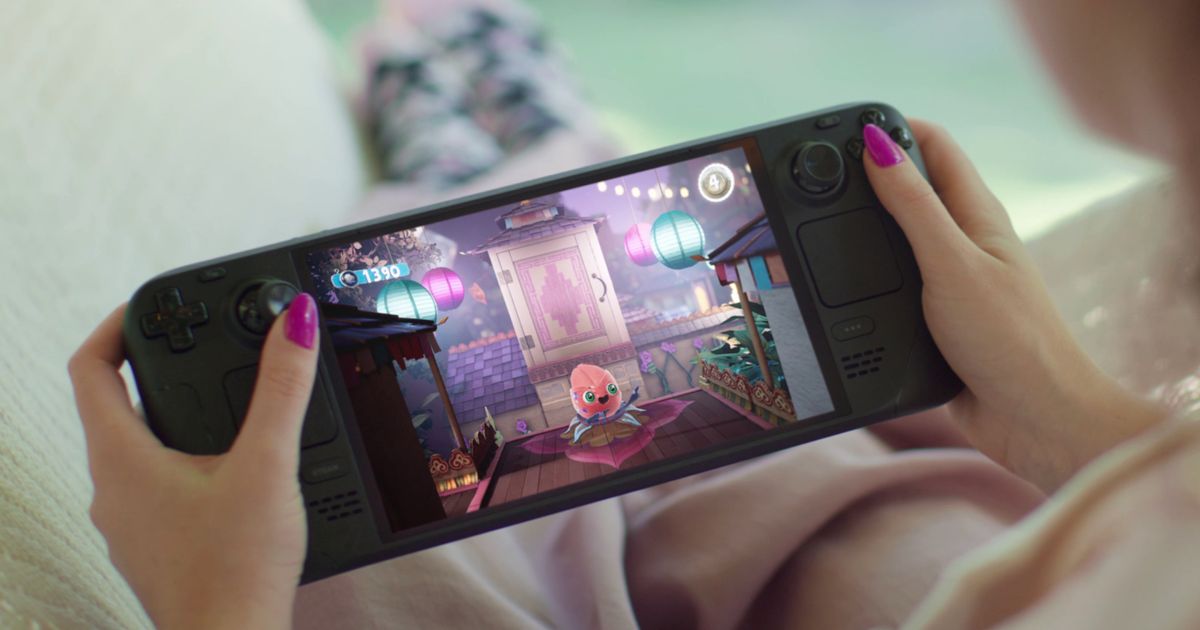 Someone with pink painted nails playing a black handheld console.