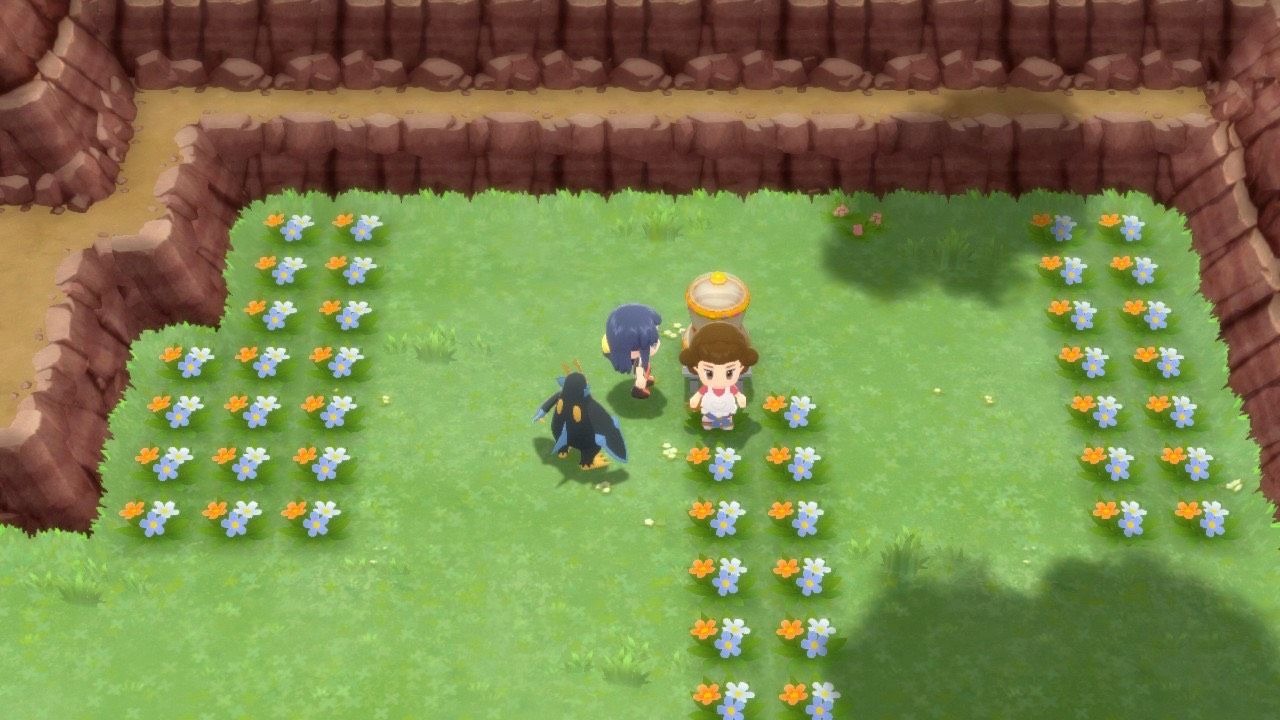A Pokémon Trainer walking with their Empoleon in Amity Square of Hearthome City, standing by the Poffin maker, in Pokémon Brilliant Diamond and Shining Pearl.